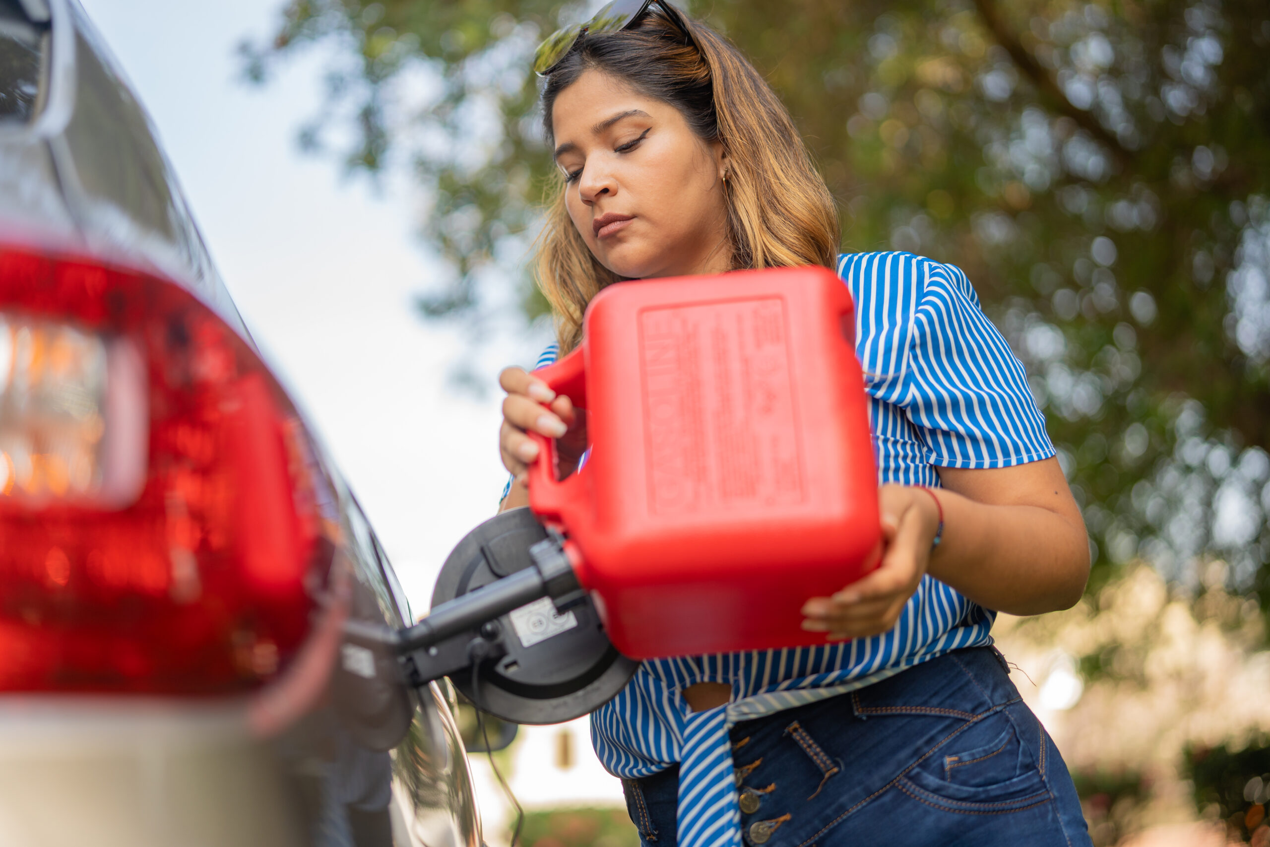 Woman adding gasoline to her vehicle in the park
